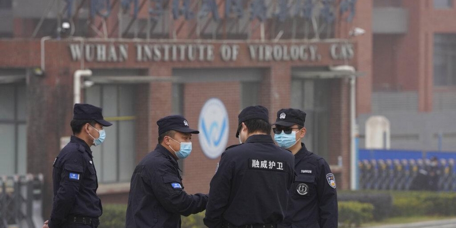 Security personnel gather near the entrance of the Wuhan Institute of Virology during a visit by the World Health Organization team. (Photo | AP)