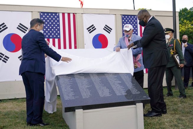 South Korean President Moon Jae-in, left, and Secretary of Defense Lloyd Austin, right, look at a replica of a section of the Wall of Remembrance at the Korean War Veterans Memorial in Washington, Friday, May 21, 2021, during a groundbreaking ceremony. The Korean War Veterans Memorial Wall of Remembrance is a long-planned addition to the existing Korean War Veterans Memorial and will display the names of the U.S. military and Korean Augmentation to the United States Army personnel who gave their lives defending South Korea's people from aggression and ensuring their freedom. (AP Photo/Susan Walsh)