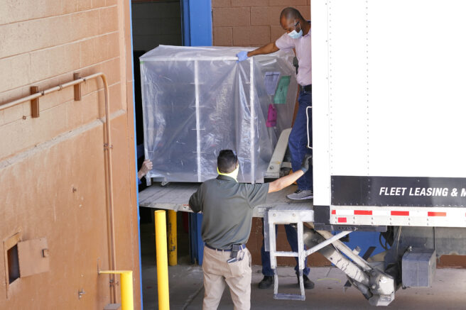 FILE - In this Wednesday, April 21, 2021 file photo, officials unload election equipment into the Veterans Memorial Coliseum at the state fairgrounds in Phoenix. Maricopa County officials began delivering equipment used in the November election won by President Joe Biden on Wednesday and will move 2.1 million ballots to the site Thursday so Republicans in the state Senate who have expressed uncertainty that Biden's victory was legitimate can recount them and audit the results. (AP Photo/Matt York)