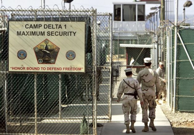 In this file photo reviewed by a U.S. Department of Defense official, U.S. military guards walk within Camp Delta military-run prison, at the Guantanamo Bay U.S. Naval Base, Cuba. (AP Photo/Brennan Linsley, File)