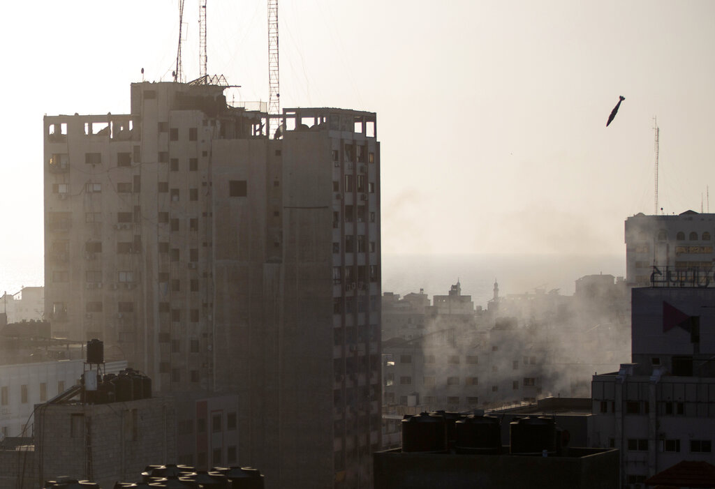 An Israeli missile flies down to hit a building in Gaza City, Wednesday, May 12, 2021. The Israeli airstrike was the latest in a series of assaults on targets in the Gaza Strip after a long dispute between Israel and Hamas erupted into an exchange of rocket attacks from Gaza and Israeli retaliation. (AP Photo/Khalil Hamra)