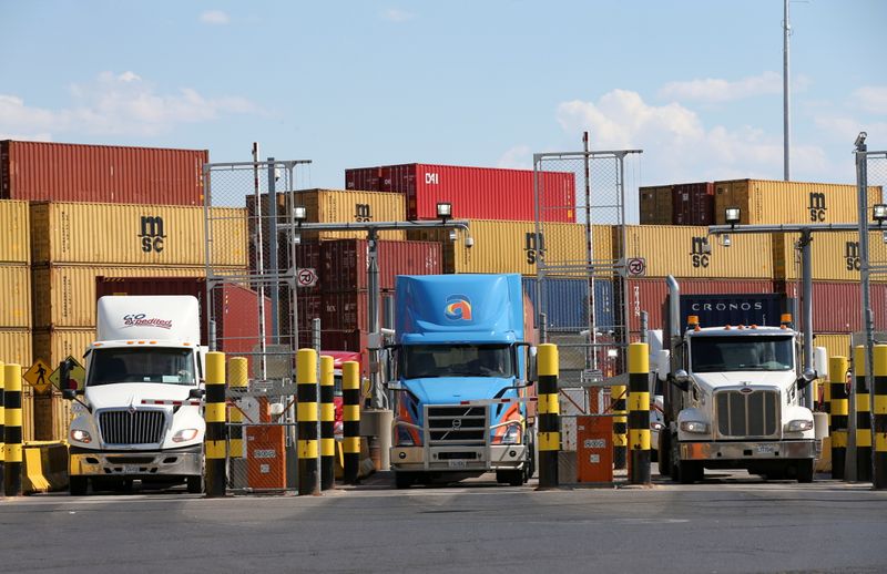 FILE PHOTO: Trucks loaded with shipping containers leave the Port of Montreal