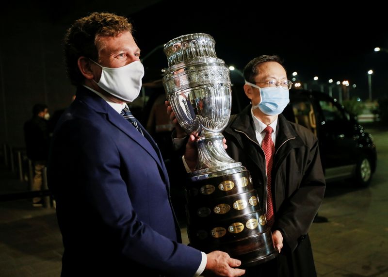 Alejandro Dominguez, president of CONMEBOL, with Chinese Ambassador to Uruguay Wang Gang hold the Copa America trophy in Montevideo