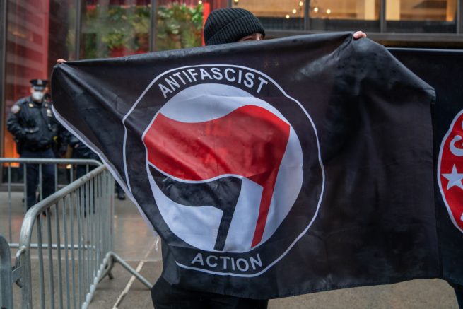 NEW YORK, NY - APRIL 11: People hold Antifa flags at Trump Tower to counter protest the "White Lives Matter" march and rally on April 11, 2021 in New York City. The march was organized on the encrypted messaging platform Telegram over the last month with a call for nationwide action. (Photo by David Dee Delgado/Getty Images)