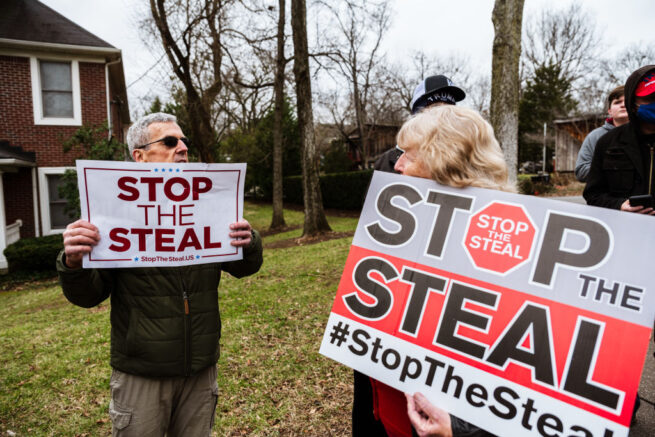  LOUISVILLE, KY - JANUARY 02: DC Under Siege protesters display their Stop The Steal signs in front Sen. Majority Leader Mitch McConnell's vandalized home on January 2, 2021 in Louisville, Kentucky. Black Lives Matter demonstrators and right-wing DC Under Siege members gathered during the Won't Back Down Rally to protest Sen. McConnell's decision to block the most recent stimulus bill. (Photo by Jon Cherry/Getty Images)