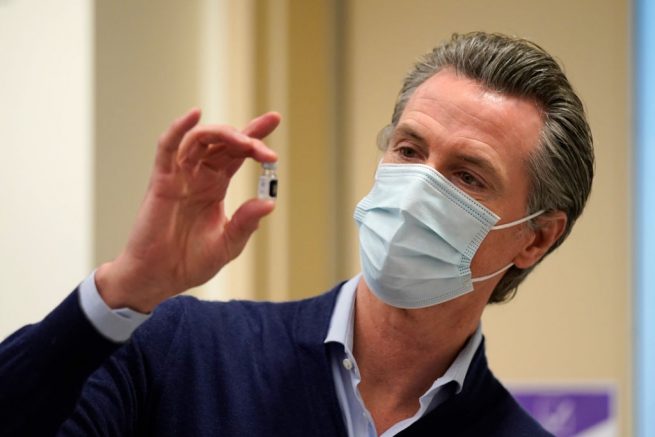 LOS ANGELES, CALIFORNIA - DECEMBER 14: Gov. Gavin Newsom holds up a vial of the Pfizer-BioNTech COVID-19 vaccine at Kaiser Permanente Los Angeles Medical Center on December 14, 2020 in Los Angeles, California. The first doses of the vaccine are being administered to frontline workers in hospitals across the country today. (Photo by Jae C. Hong-Pool/Getty Images)