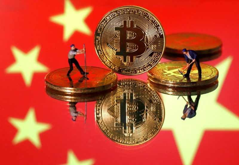 FILE PHOTO: Picture illustration of small toy figurines and representations of the Bitcoin virtual currency displayed in front of an image of China's flag