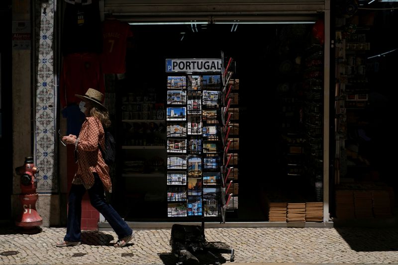 FILE PHOTO: A woman wearing a protective mask walks in Lisbon downtown amid the coronavirus disease (COVID-19) pandemic, in Lisbon