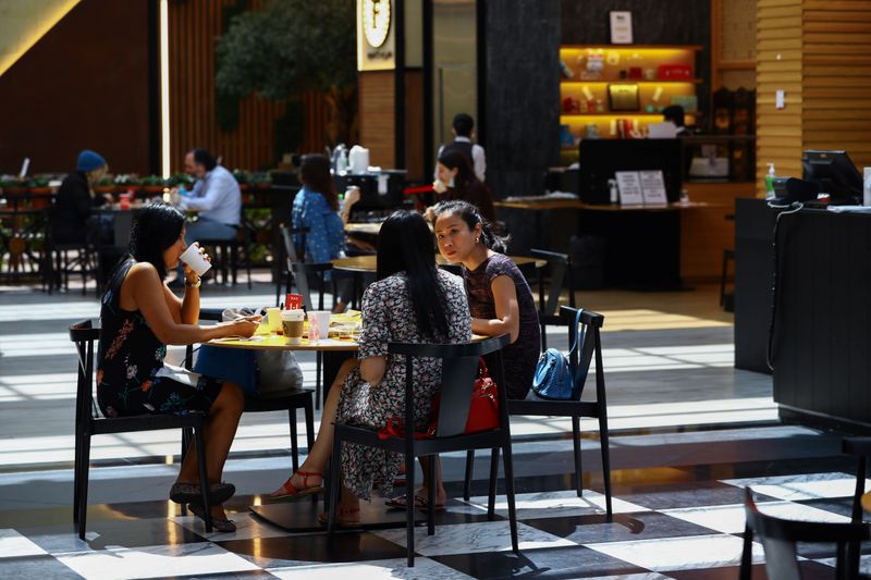 People sit in a coffee shop during the reopening of malls, following the outbreak of the coronavirus disease (COVID-19), at Mall of the Emirates in Dubai