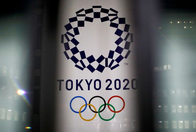 FILE PHOTO: FILE PHOTO: The logo of Tokyo 2020 Olympic Games is seen through signboards, in Tokyo