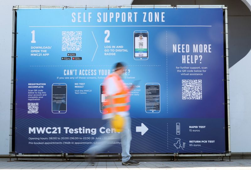 Worker walks past a sign ahead of the Mobile World Congress (MWC) at Fira de Barcelona