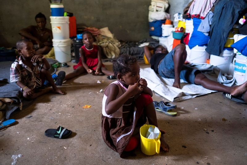 People shelter inside a school after their settlement was burned down by gangs in Port-au-Prince