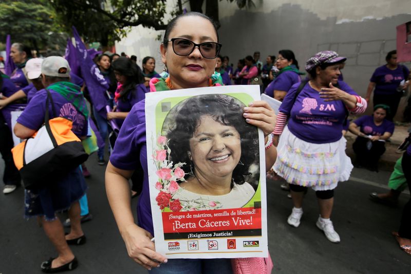 FILE PHOTO: A woman holds a poster with a photo of slain indigenous environmental activist Berta Caceres during a protest to mark International Women's Day outside the public prosecutor's office in Tegucigalpa