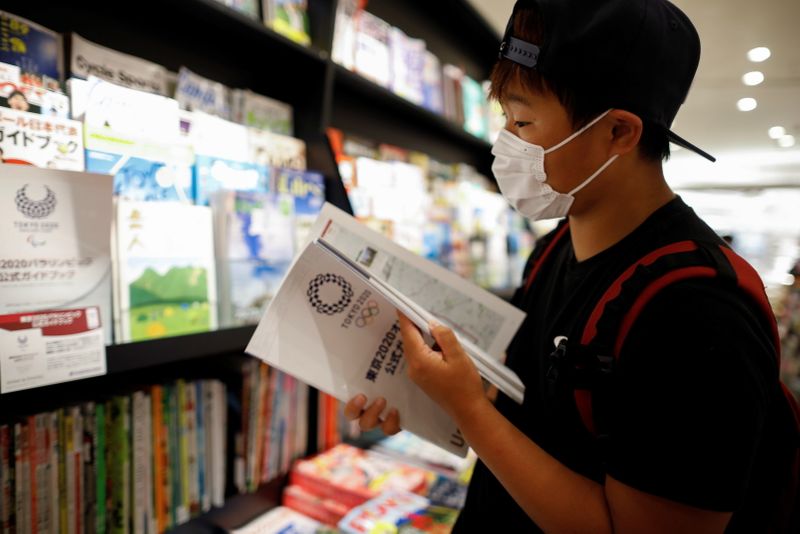 So Sato, a deaf and transgender pole vaulter, checks the official guide book for the Tokyo 2020 Olympic Games at a book store in Tokyo