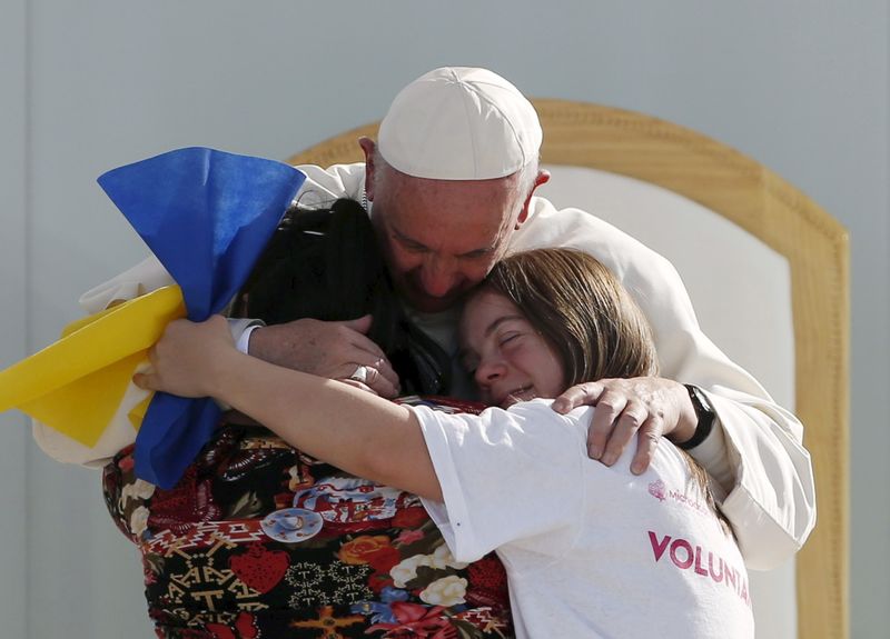 Pope Francis hugs two girls during a meeting with youths at the Jose Maria Morelos y Pavon stadium in Morelia