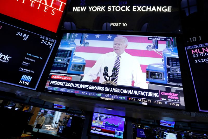 A screen displays the U.S. President Biden's remarks on American manufacturing on the trading floor at New York Stock Exchange (NYSE) in New York City, New York