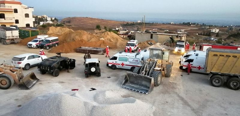 Lebanese army soldiers and Red Cross members are seen near the site of a fuel tanker explosion in Akkar