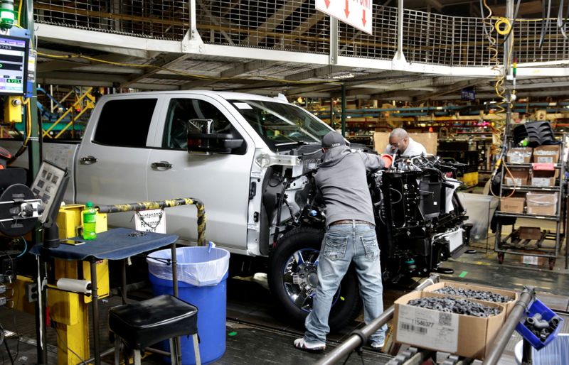 FILE PHOTO: GM assembly workers work on Chevrolet heavy-duty pickup trucks at the GM Flint Assembly Plant