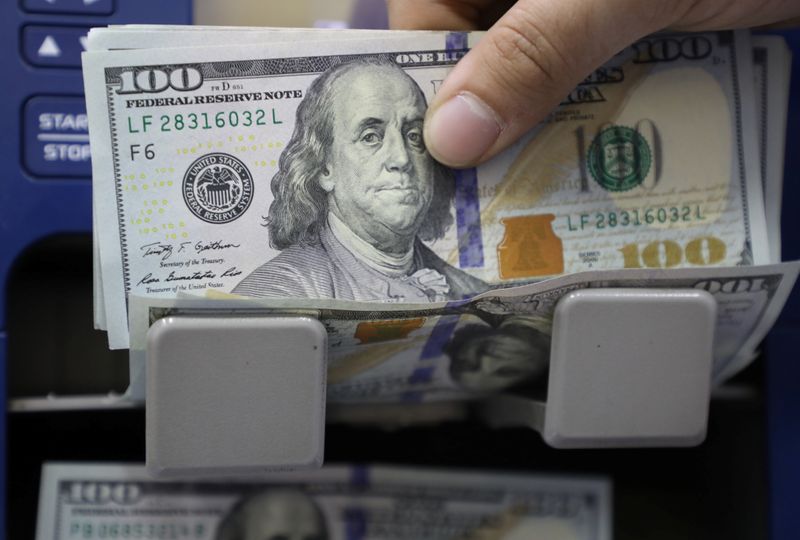 A man counts U.S. dollar banknotes at a currency exchange shop in Beirut