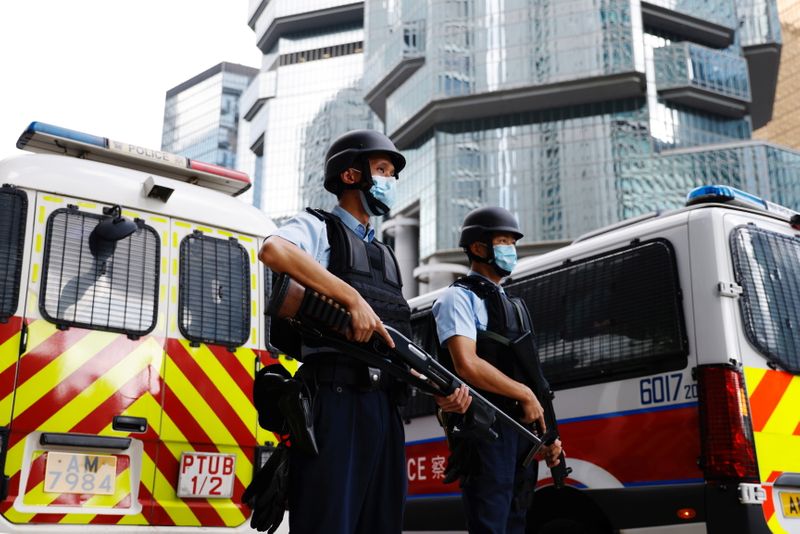 Armed police stand guard as a prison van carrying Andy Li, one of the 12 activists intercepted by mainland authorities in August 2020 on a boat allegedly en route to Taiwan, arrives at the high court, in Hong Kong