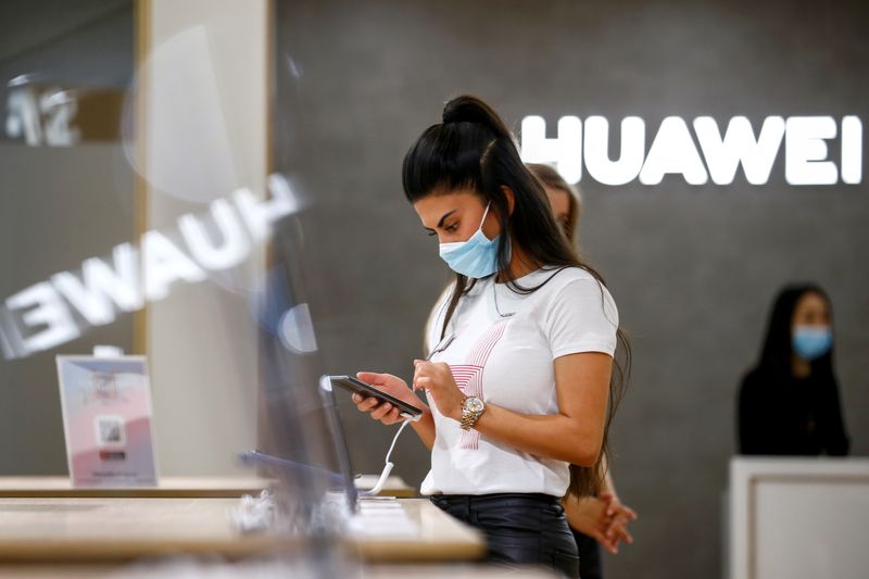 FILE PHOTO: An employee uses a Huawei P40 smartphone at the IFA consumer technology fair, in Berlin