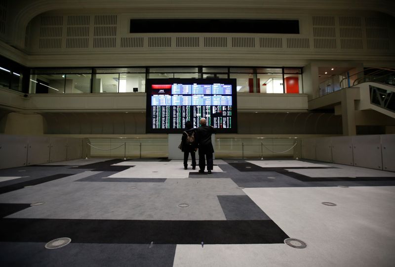 Visitors looks at an electronic board showing the Japan's Nikkei average at the Tokyo Stock Exchange in Tokyo