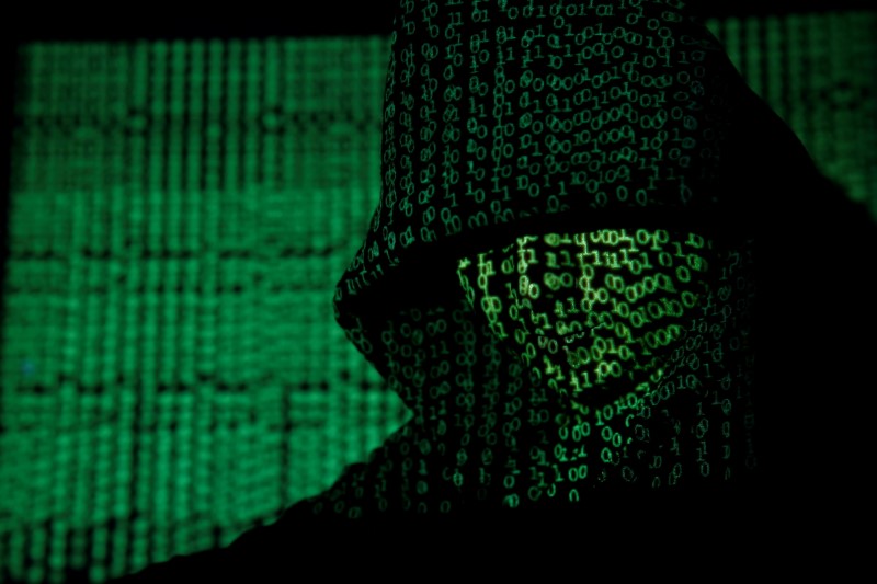 FILE PHOTO: Projection of cyber code on hooded man is pictured in this illustration picture