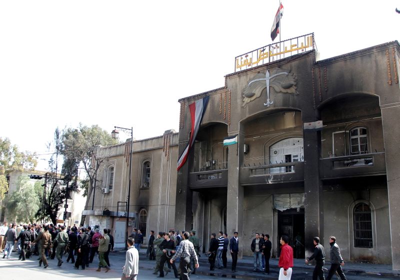 FILE PHOTO: People walk past the main courthouse in Deraa
