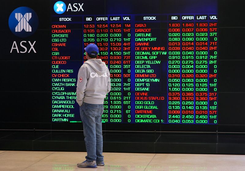 An investor looks at a board displaying stock prices at the Australian Securities Exchange (ASX) in Sydney, Australia