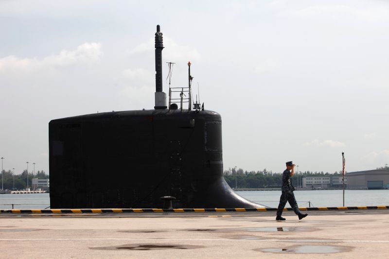 U.S. Navy personel walks past USS North Carolina submarine docked at Changi Naval Base in Singapore