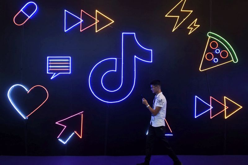 Man walks past a sign of ByteDance's app TikTok, known locally as Douyin, at an expo in Hangzhou