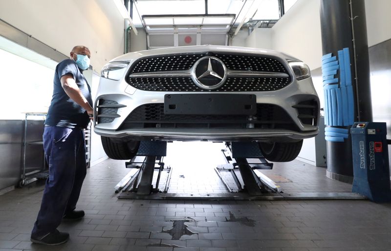 FILE PHOTO: An employee at a Mercedes-Benz dealership wearing a protective mask prepares a vehicle, amid the coronavirus disease (COVID-19) outbreak in Brussels