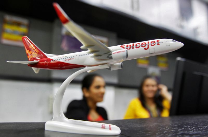 FILE PHOTO: Employees work inside a travel agency office beside a model of a SpiceJet aircraft in Ahmedabad