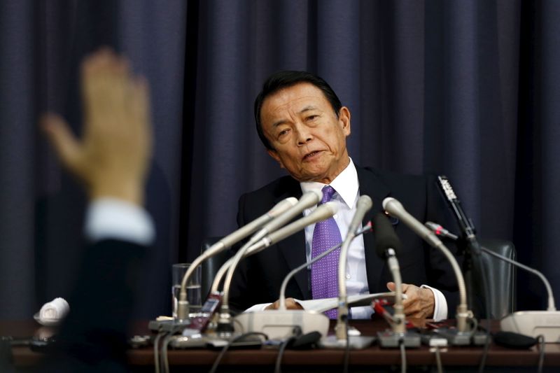 Japan's Finance Minister Taro Aso attends a news conference as a reporter raises his hand for a question at the Finance Ministry in Tokyo