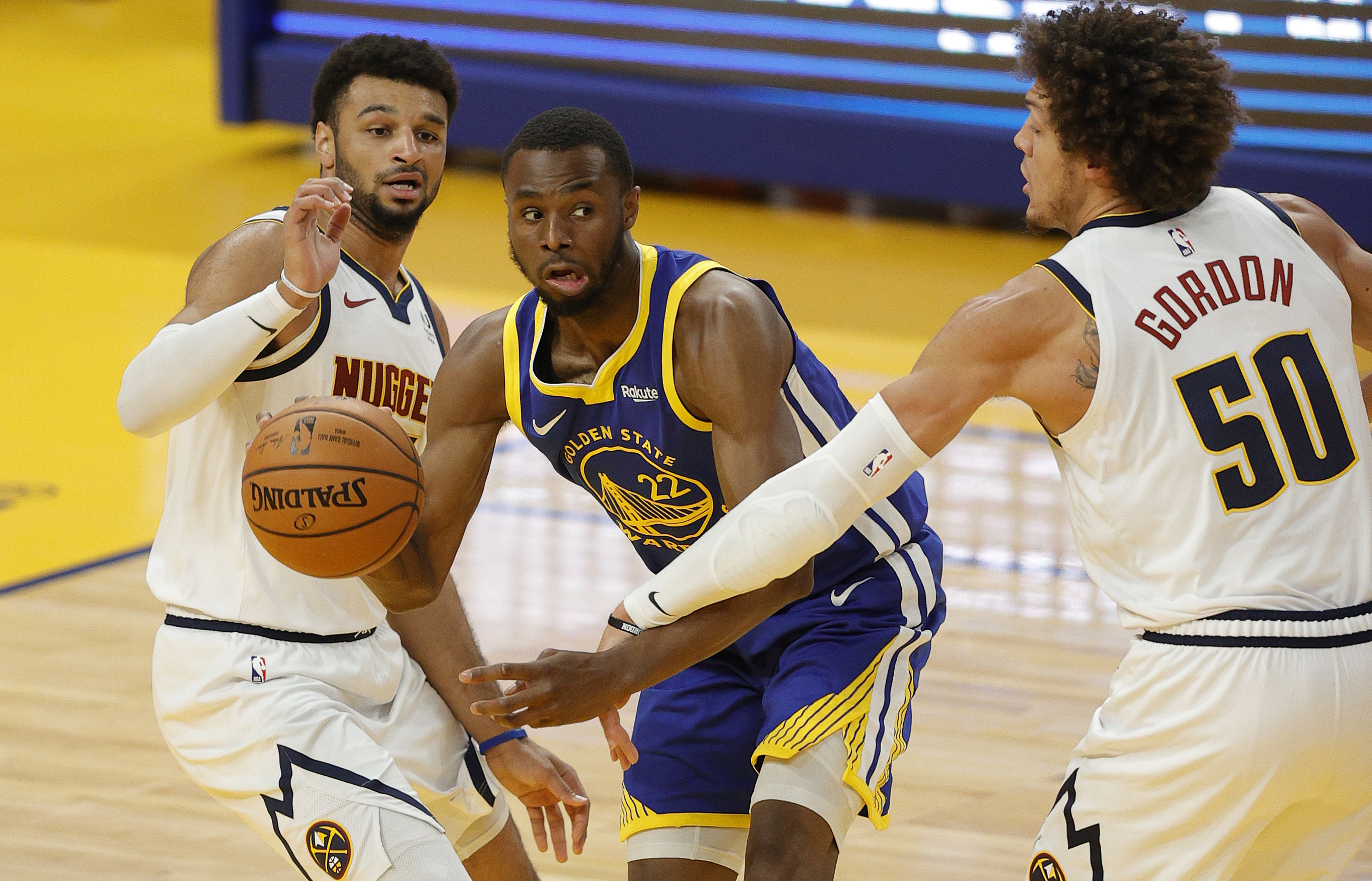 Andrew Wiggins #22 of the Golden State Warriors is guarded by Aaron Gordon #50 and Jamal Murray #27 of the Denver Nuggets at Chase Center on April 12, 2021 in San Francisco, California. (Photo by Ezra Shaw/Getty Images)