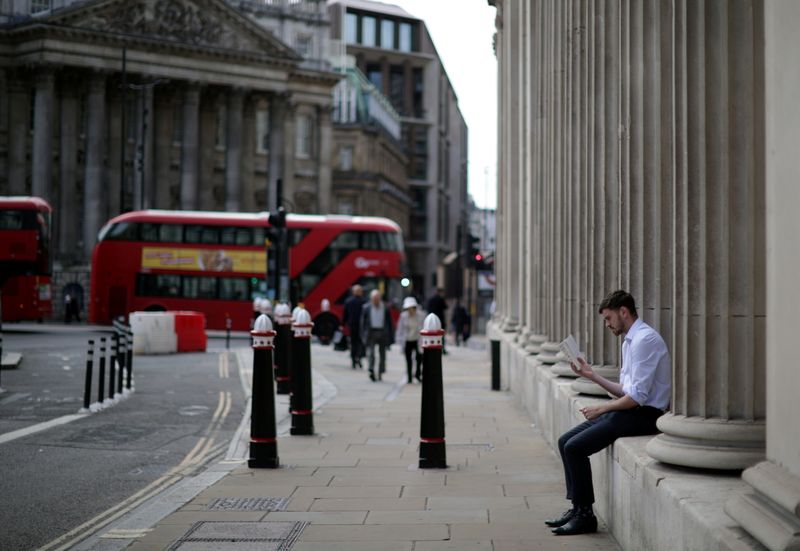 A person reads a book outside the Bank of England in London