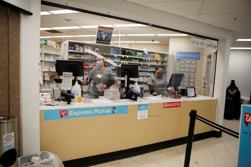 FILE PHOTO: People work behind a pharmacy counter as people are inoculated against the coronavirus disease (COVID-19) at a Walgreens store in Chicago