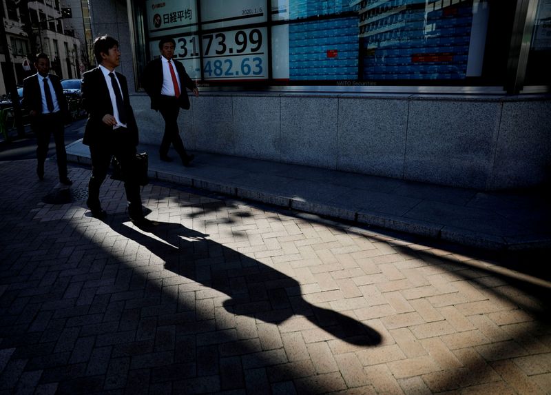 A man looks at a board showing stock prices outside a brokerage in Tokyo,