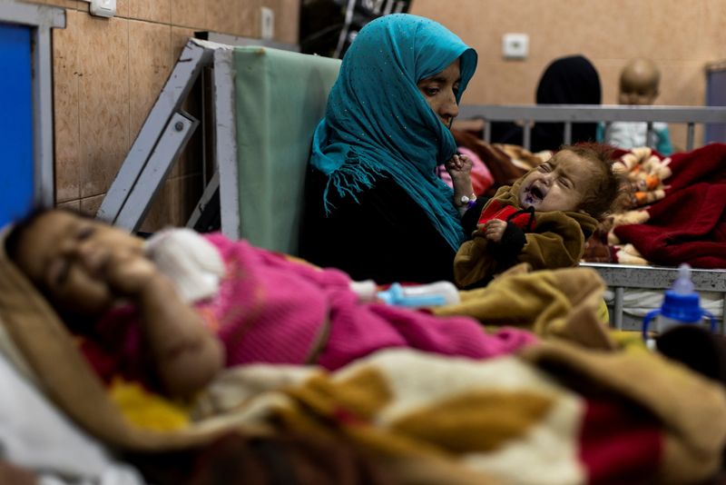 A mother holds her baby at the malnutrition ward of Indira Gandhi hospital in Kabul