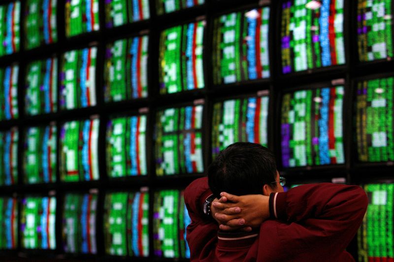 FILE PHOTO: A man looks at stock market monitors in Taiwan