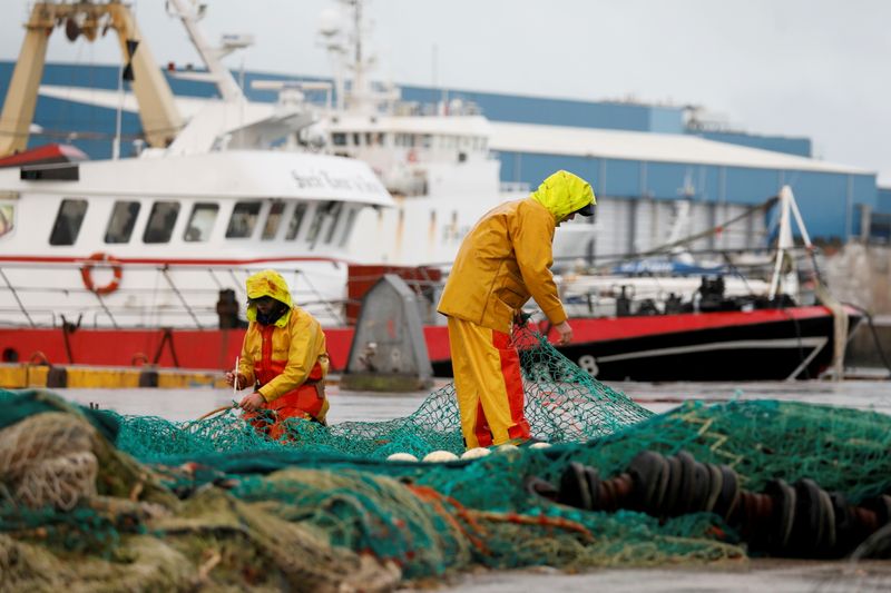 FILE PHOTO: French fishermen repair their nets at Boulogne-sur-Mer, northern France