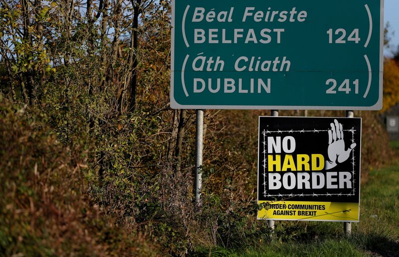 FILE PHOTO: A 'No Hard Border' poster is seen below a road sign on the Irish side of the border between Ireland and Northern Ireland near Bridgend