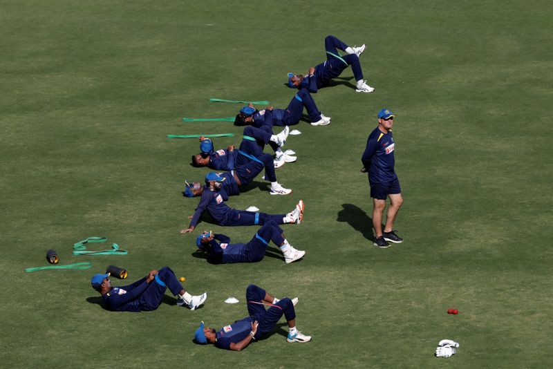 Sri Lanka's cricket coach Arthur walks as team players stretch at National Stadium, Karachi