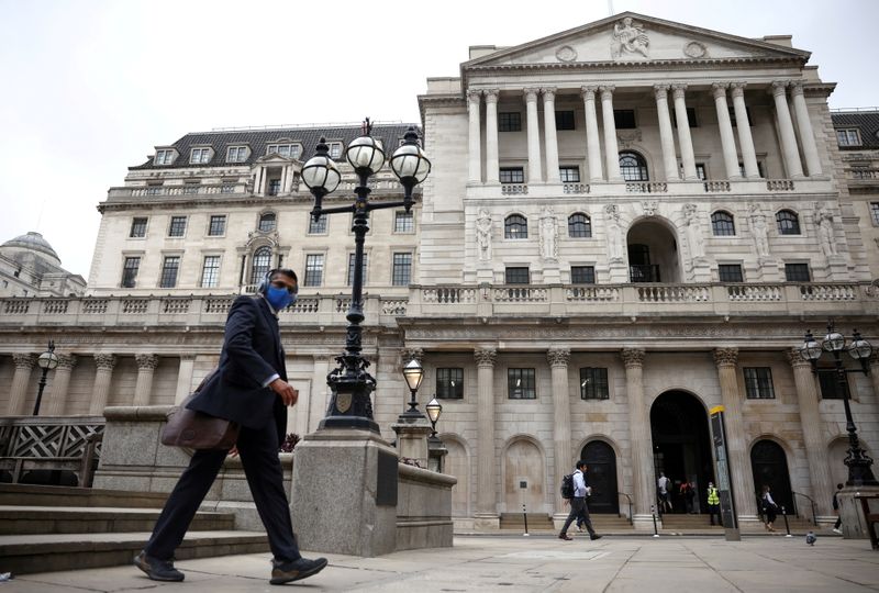 FILE PHOTO: A person walks past the Bank of England in the City of London financial district