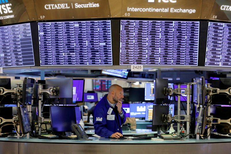 FILE PHOTO: A trader works on the trading floor at the New York Stock Exchange (NYSE) in Manhattan, New York City