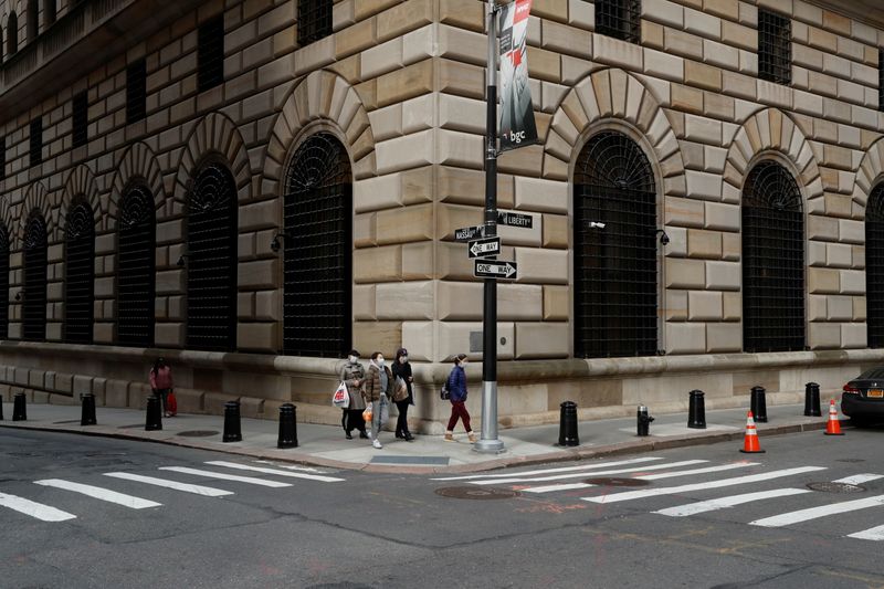 FILE PHOTO: People walk wearing masks outside The Federal Reserve Bank of New York in New York