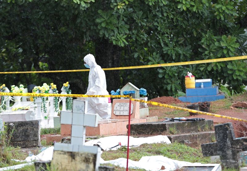 A member of a forensic team walks in the area during the exhumation of the remains of victims of the 1989 U.S. invasion, in Colon