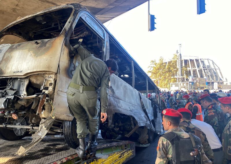 Security forces inspect the site of an explosion in central Damascus