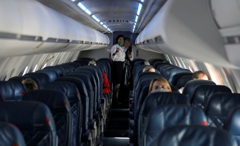 Flight attendants talk in a nearly empty cabin on a Delta Airlines flight operated by SkyWest Airlines