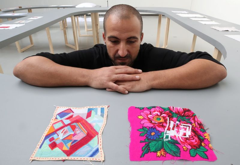 Palestinian artist Majd Abdel Hamid poses for Reuters during his exhibition in Brussels